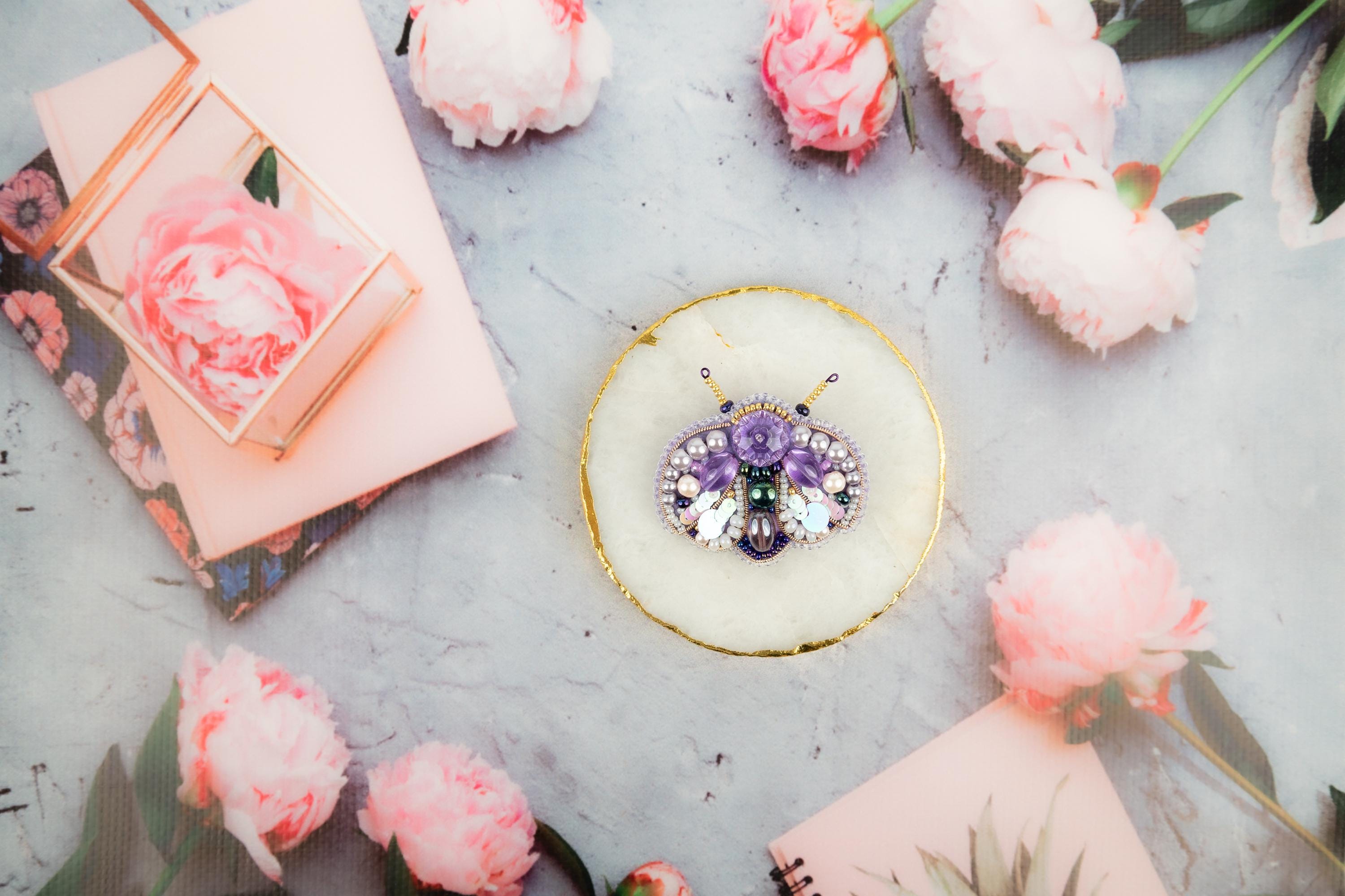 a table topped with pink flowers and jewelry